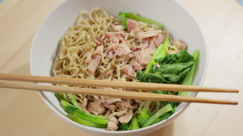 Chopsticks On A Bowl Of Bakmi Wheat Noodles Served With Bok Choy And Meat. closeup, rotating Royalty-Free Stock Footage #3450645293