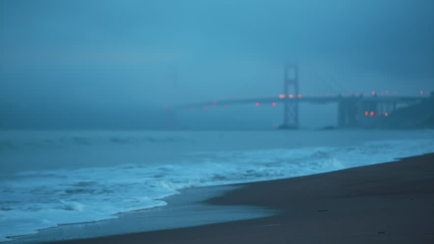 Fog enshrouded Golden Gate Bridge viewed from Baker Beach in San Francisco during an early morning
