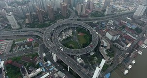 SHANGHAI, CHINA – JUNE 2016 : Aerial shot over Yangpu Bridge with view of roundabout traffic and skyline at daytime