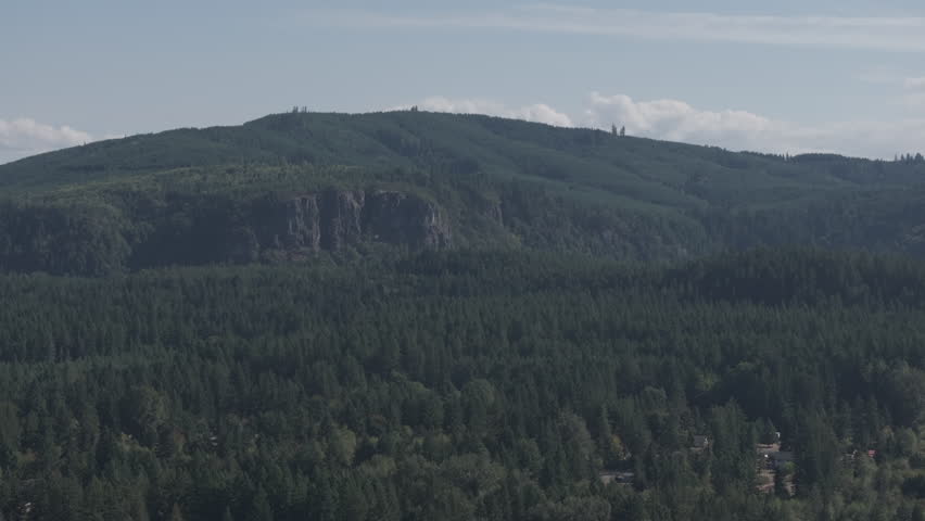 Ungraded wide angle aerial drone footage of mountains and forest on a sunny day in Washington State. 