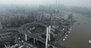 SHANGHAI, CHINA – JUNE 2016 : Aerial shot over Huangpu River with Yangpu Bridge and Shanghai skyline in view at daytime