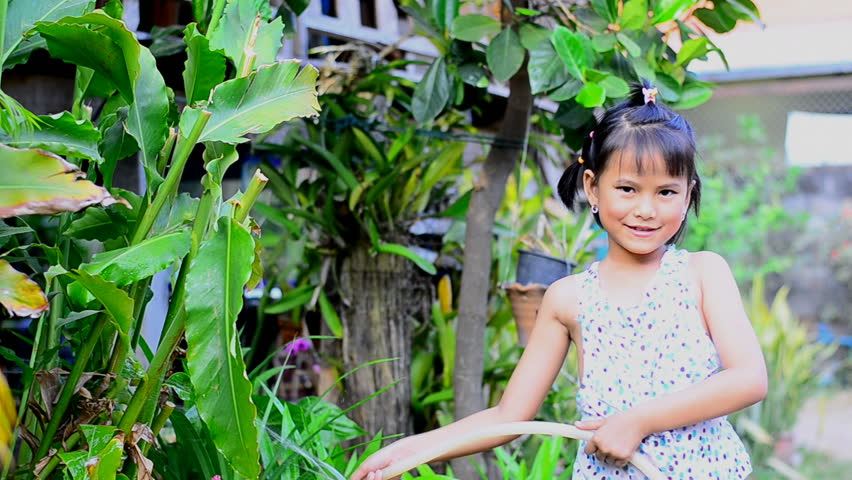 Little girl watering plant in the garden