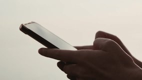Close-up footage of female hands holding cell phone and scrolling social media content outdoors. Woman using smartphone at sunset. - Powered by Shutterstock - Get 15% off with code: PIKWIZARD15