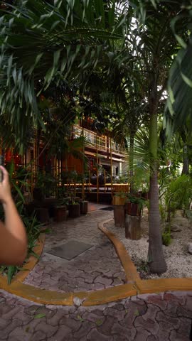 young hispanic woman tourist walks and films with her cell phone