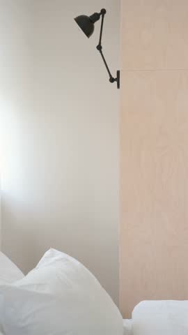 close-up to the black wall lamp and part of the bed