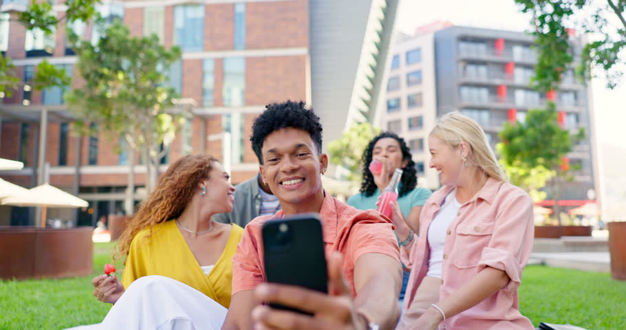 College student, friends and selfie at picnic in park with smile for eating fruit, drink or relax at campus. Men, women and gen z group on grass for funny memory, photography or app for social media