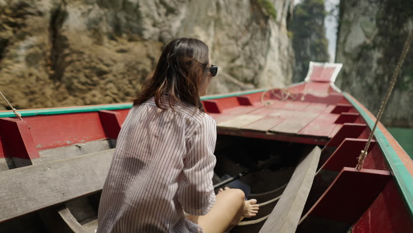 A woman in a striped shirt sits in the boat