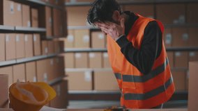 Exhausted warehouse worker having a bad headache, he is touching his forehead - Powered by Shutterstock - Get 15% off with code: PIKWIZARD15