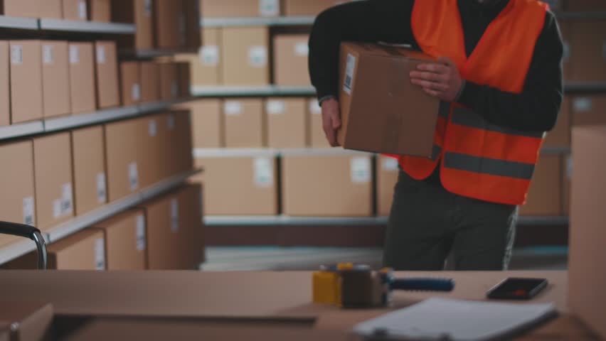 Tired warehouse worker having back pain after lifting heavy boxes Royalty-Free Stock Footage #3450907449