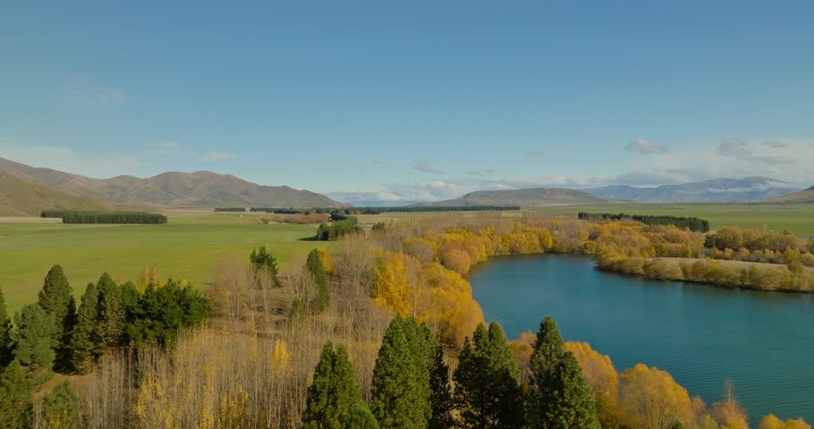 Fall season in New Zealand with color changing trees on shore of lake