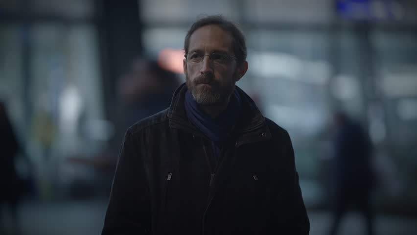 Male Person with Glasses Standing Out of the Crowd Thoughtfully Uncertain