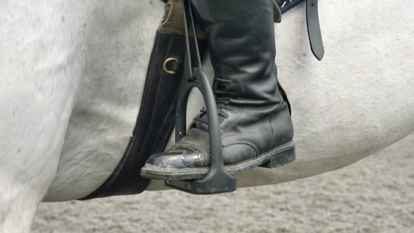 Legs close-up of a jockey sitting on a horse.