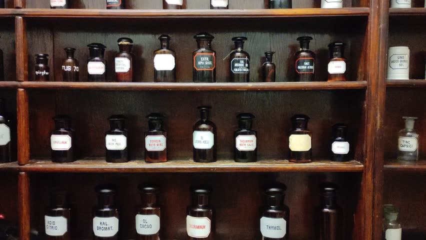 Vintage shelves with antique bottles of medicine or alcohol. An ancient pharmacy, bar or alchemy workshop.