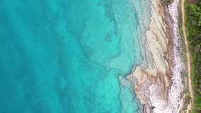 Aerial top down view of Croatia coastline with turquoise water, limestone coast and vegetation. Tracking footage