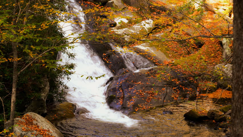 Waterfall cascades over rocks in the Appalachian mountains of Tennessee during autumn