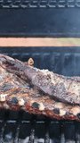 BBQ hot flaming grill is roasting marinated pork ribs