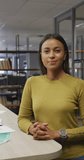 Vertical video of portrait of happy biracial businesswoman in office. global business in creative office.
