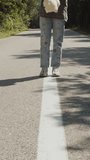 Girl with a plush toy in her hands walking on road markings, vertical video
