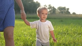 mother and baby son walking in the park. happy family walking in the park in nature relaxing outdoors. happy family kid dream concept. mother lifestyle and child walking in the park - Powered by Shutterstock - Get 15% off with code: PIKWIZARD15