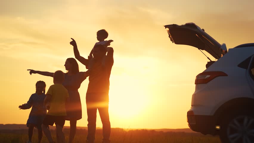 family by car resting in the park. family and children silhouette resting on the car playing ball at sunset in park on vacation. happy family kid dream concept. camping by sun car in the park