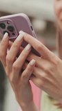 Vertical video, Close-up of woman's hands using mobile phone, scrolling, looking at photo