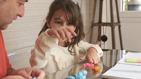 Grandfather and granddaughter playing with plasticine