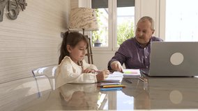 Girl painting next to her grandpa while working on a laptop at home