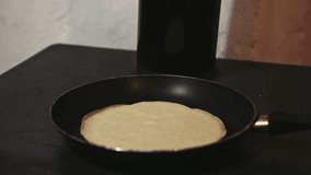 Close up video of flipping pancakes while preparing delicious crepes on frying pan on wood burning stove. for celebrating the Mardi Gras or Shrove Tuesday. Festive food. Culinary. Traditional cuisine
