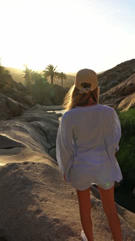 Video Blonde woman contemplating an oasis in a volcanic area