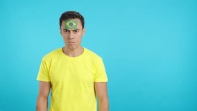 Dignified and serious man with brazilian flag painted on face