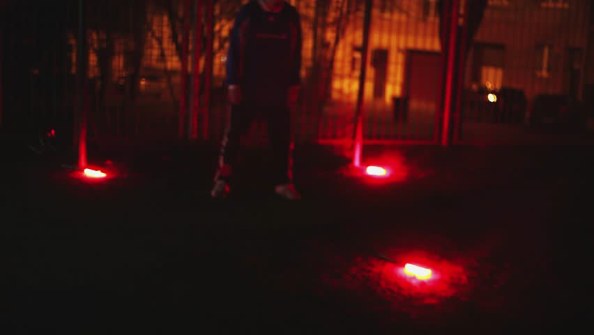 blur, night football, a group of guys playing football on a street playground at night, football players training on a football playground at night