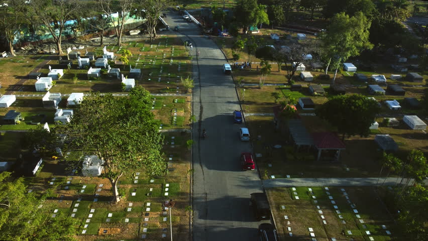 Drone tilting over a road in middle of graves in Manila memorial park, Philippines