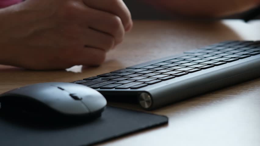Close-up view of a person hands typing rapidly on a black keyboard, with a wireless mouse lying adjacent on a wooden deck surface. The interaction indicates busy work or communication, possibly in an  Royalty-Free Stock Footage #3451771283