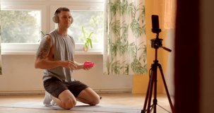 Fitness trainer during online workout session at home. Utilizing technology as smartphones and video conferencing platforms, participants engage in virtual fitness sessions from any location. Vlogger