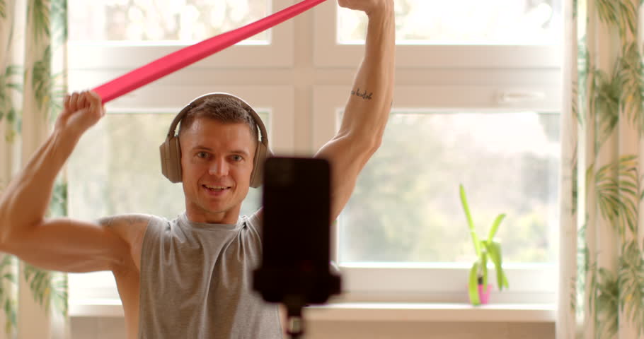 Recording a video lesson. Fitness trainer develops an online course aimed at providing comprehensive fitness instruction and guidance to participants. Man recorded video content with smartphone help. Royalty-Free Stock Footage #3451909897