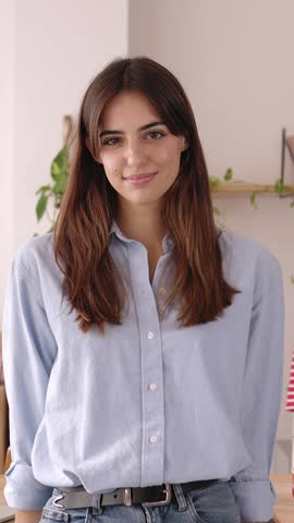 Camera dolly in portrait of young pretty entrepreneur businesswoman standing at clothing showroom. Confident small business female owner smiling at camera at workplace room. High quality 4k footage
