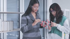 Two Asian schoolgirls are learning about molecular models in science class. - Powered by Shutterstock - Get 15% off with code: PIKWIZARD15