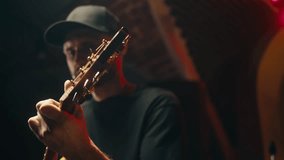 Portarait of young musician man sitting and playing acoustic guitar among music equipment in studio close-up. Guitarist plays melody  - Powered by Shutterstock - Get 15% off with code: PIKWIZARD15
