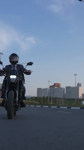 Caucasian man rides an electric motorcycle. Vertical video. 