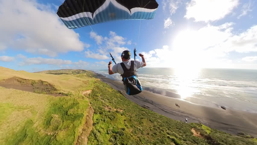 Paraglider soaring in New Zealand coast at sunset, adventure concept. Royalty-Free Stock Footage #3451993055