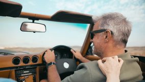 Close up of retired senior couple on vacation driving in classic sports car on road trip through countryside - shot in slow motion - Powered by Shutterstock - Get 15% off with code: PIKWIZARD15