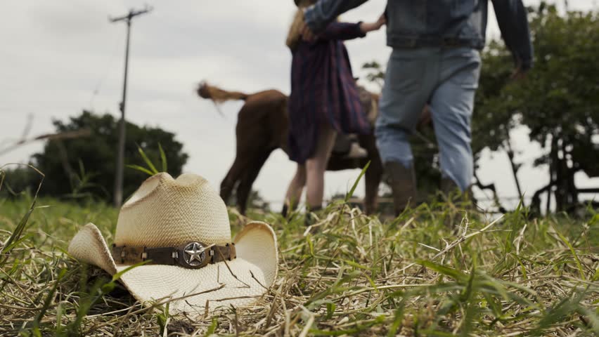 A cowgirl kisses her boyfriend at the ranch on top of her horse-4K