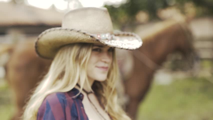 sexy cowgirl wearing a hat on her ranch with her horse-SLOWMOTION