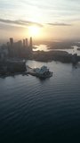 Aerial video of Sydney City and Sydney Harbor over the Sydney Harbor Bridge in the late afternoon