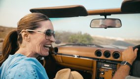 Close up of retired senior couple on vacation driving in classic sports car on road trip through countryside - shot in slow motion - Powered by Shutterstock - Get 15% off with code: PIKWIZARD15