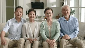 two senior asian couples sitting on couch at home watching tv together happy and smiling - Powered by Shutterstock - Get 15% off with code: PIKWIZARD15