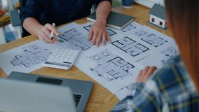 Close up of hands working brainstorming and measuring for cost estimating on paperworks and floor plan drawings about design architectural and engineering for houses and buildings. - Powered by Shutterstock - Get 15% off with code: PIKWIZARD15