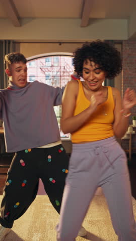 Vertical Screen: Beautiful Stylish Multiethnic Couple in Comfy Home Clothes Dancing and Enjoy Life at Home in Loft Apartment. Recording Funny Viral and Active Videos for Social Media.