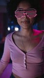 Vertical Screen: Diverse Multiethnic Young Black Female Dancing in Futuristic Neon Glowing Glasses, Having a Party at Home in Loft Apartment. Recording Funny Viral Videos for Social Media.