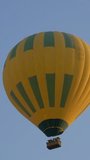 Hot air baloon flying in blue sky. Vertical video